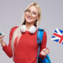 online-education-foreign-language-translator-english-student-smiling-blond-woman-headphones-holding-mobile-phone-british-flag-grey-space-distance-learning
